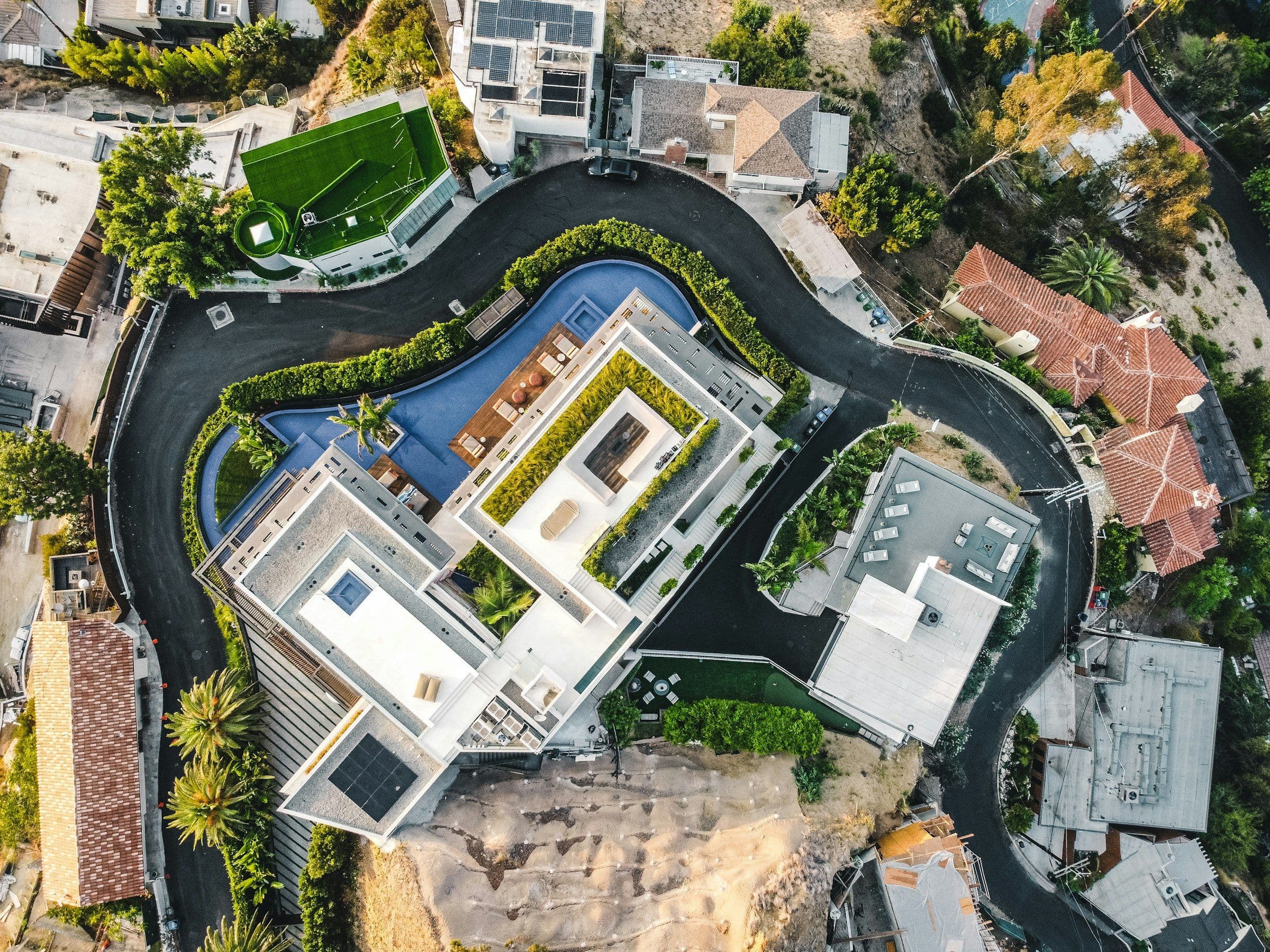 Drone view of a flat-roof contemporary mansion with a pool