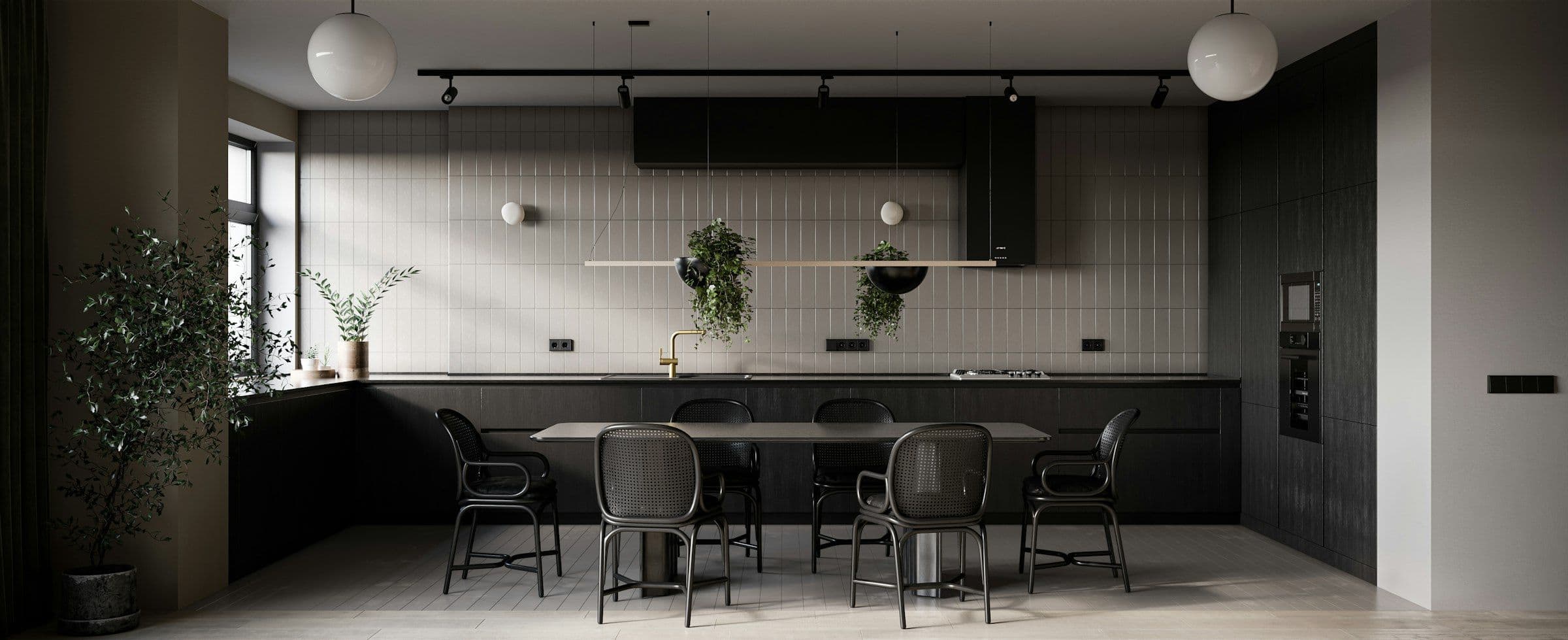 Black kitchen and long dining table under globe pendants