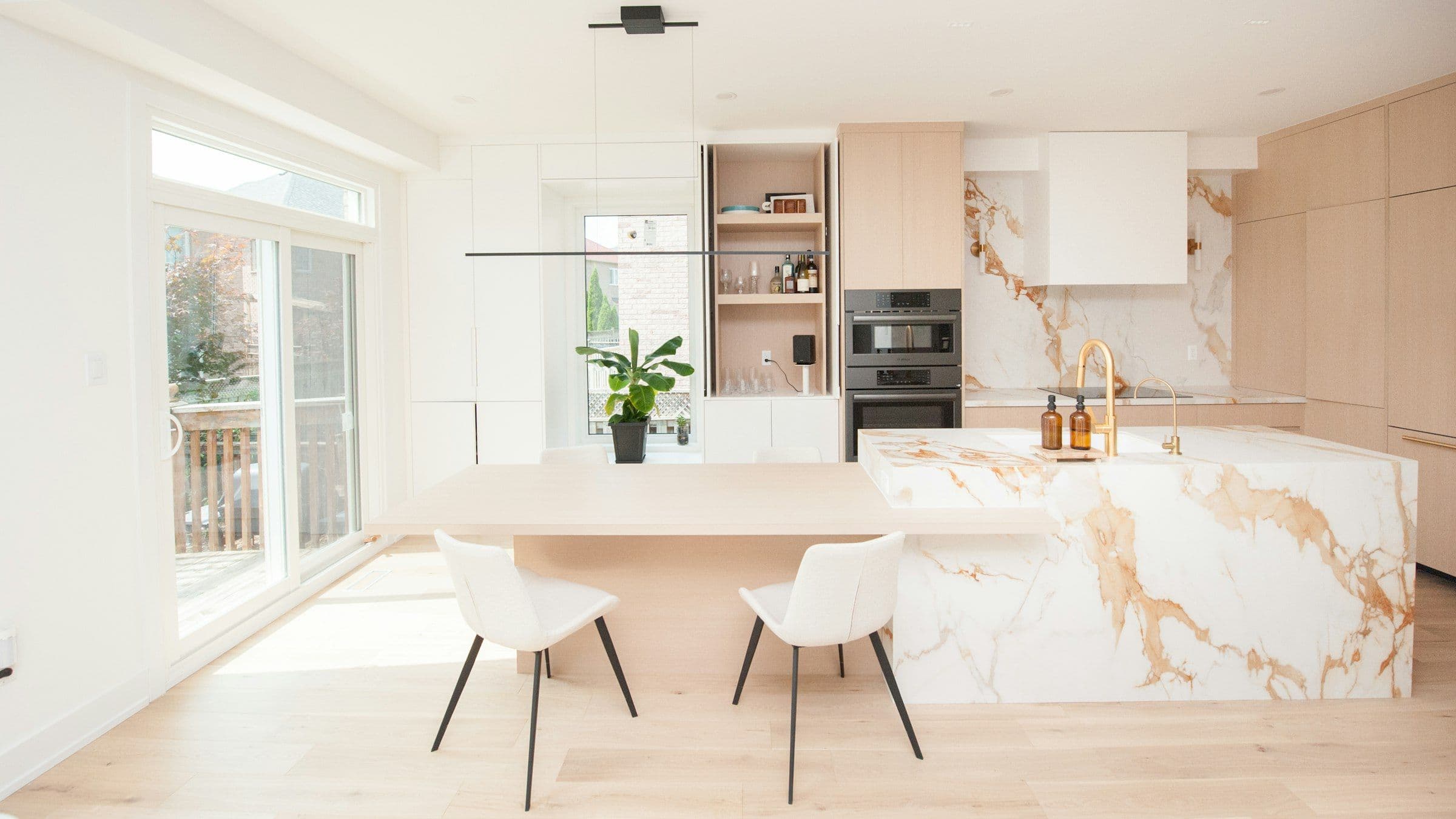 Gold-veined marble waterfall island in a light oak kitchen