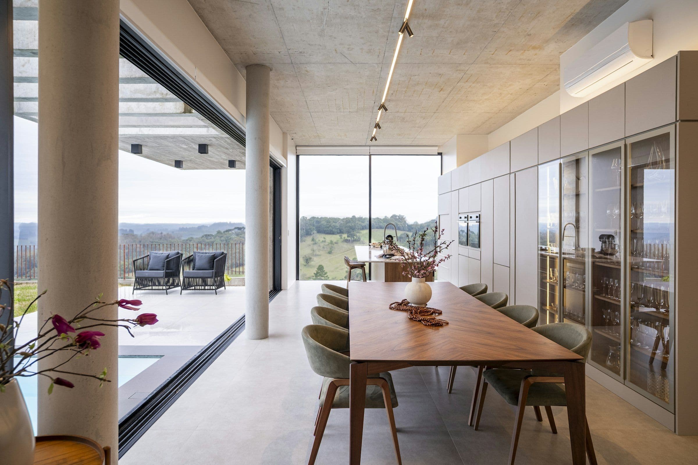 Dining room with corner glass walls opening fully to the terrace