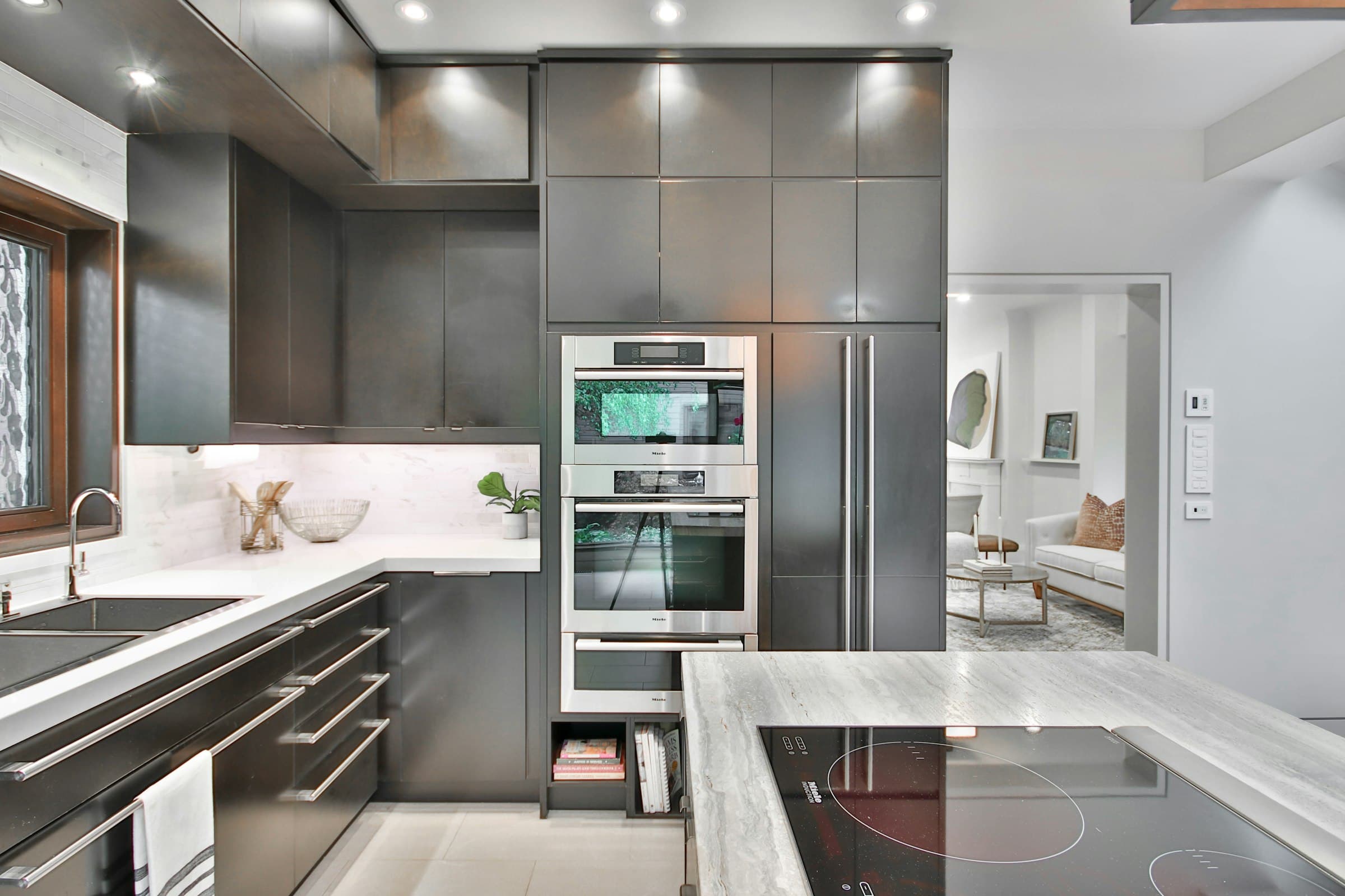 Dark lacquered kitchen with marble counters and built-in ovens