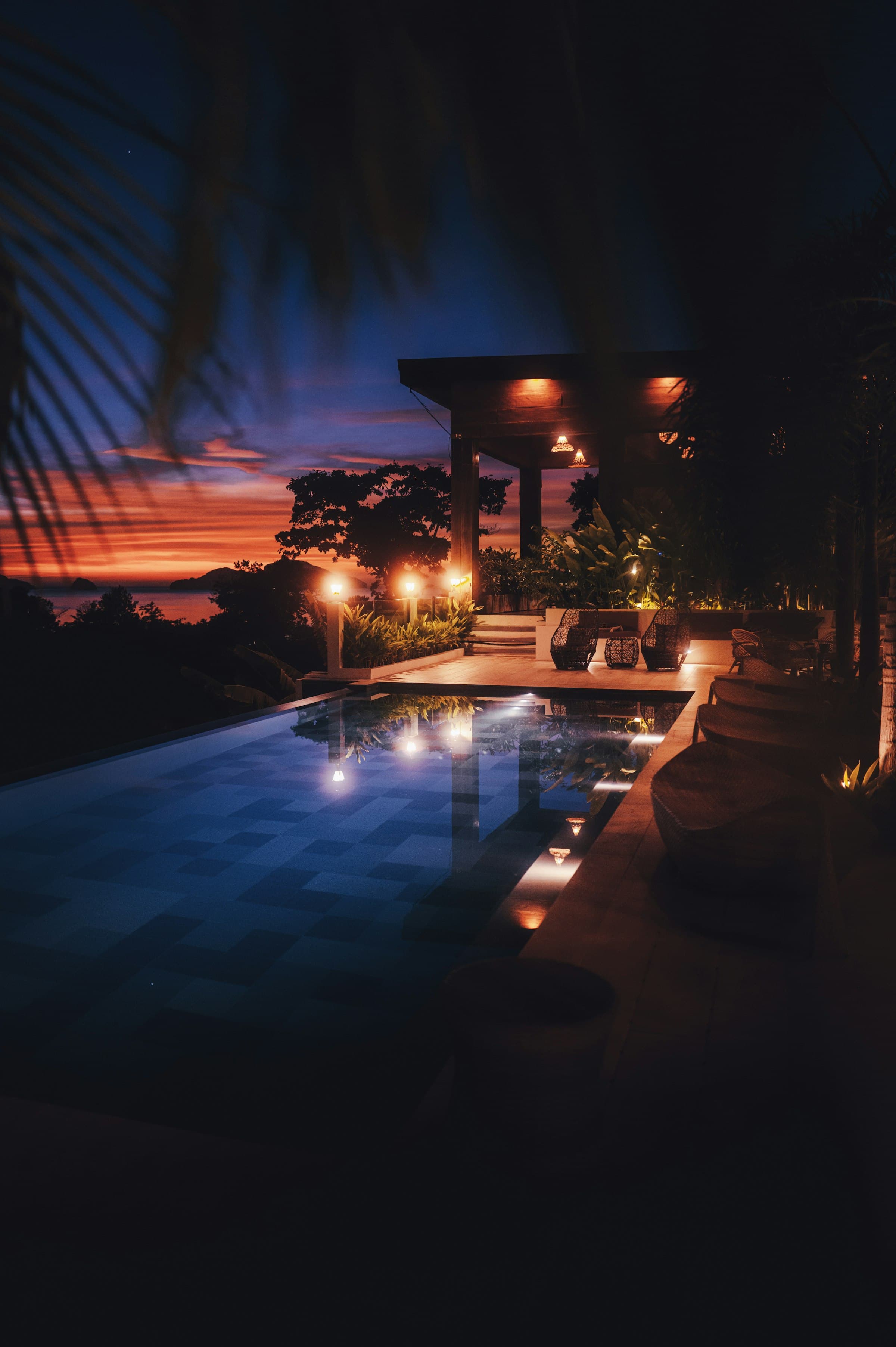 Lantern-lit infinity pool at twilight