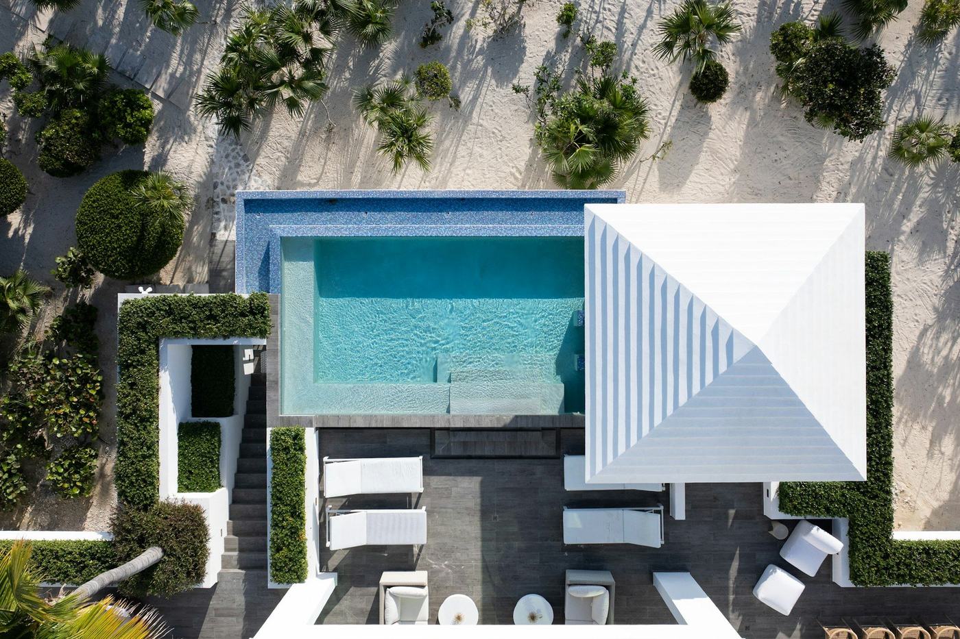 Overhead drone view of a white roof and pool deck