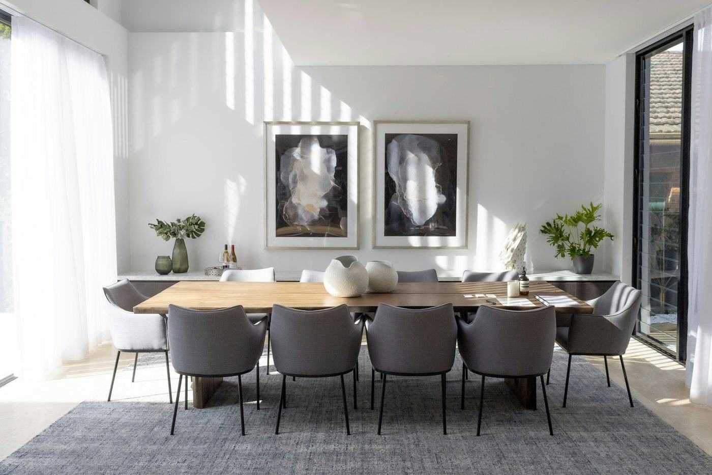 Staged white dining room with a pool beyond the glass doors