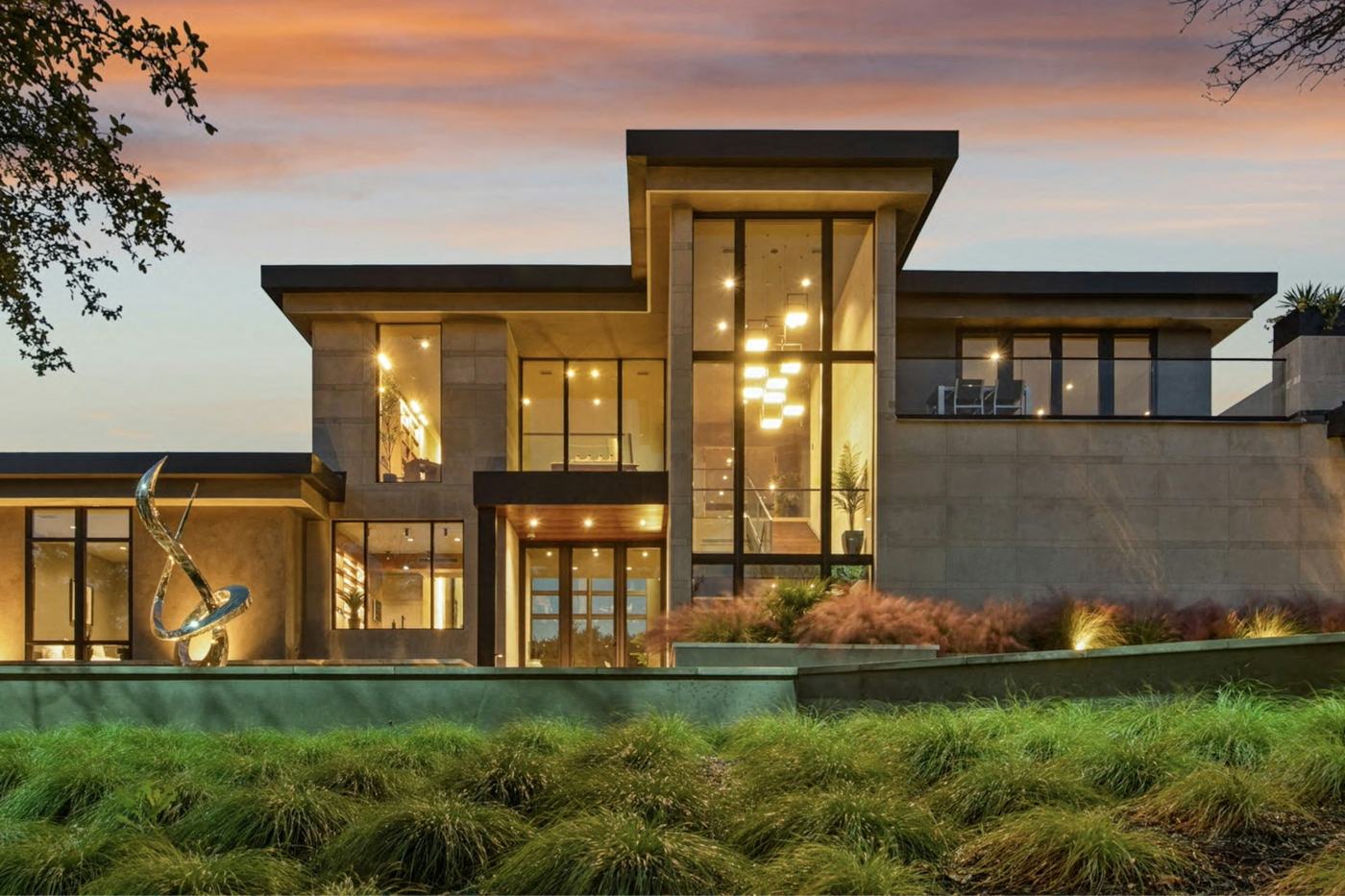 Contemporary luxury home glowing with warm interior light at dusk