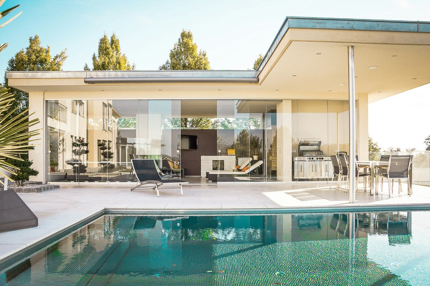 Pool and covered pool house with glass walls